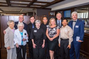 Diverse group of business professionals standing together at corporate event.