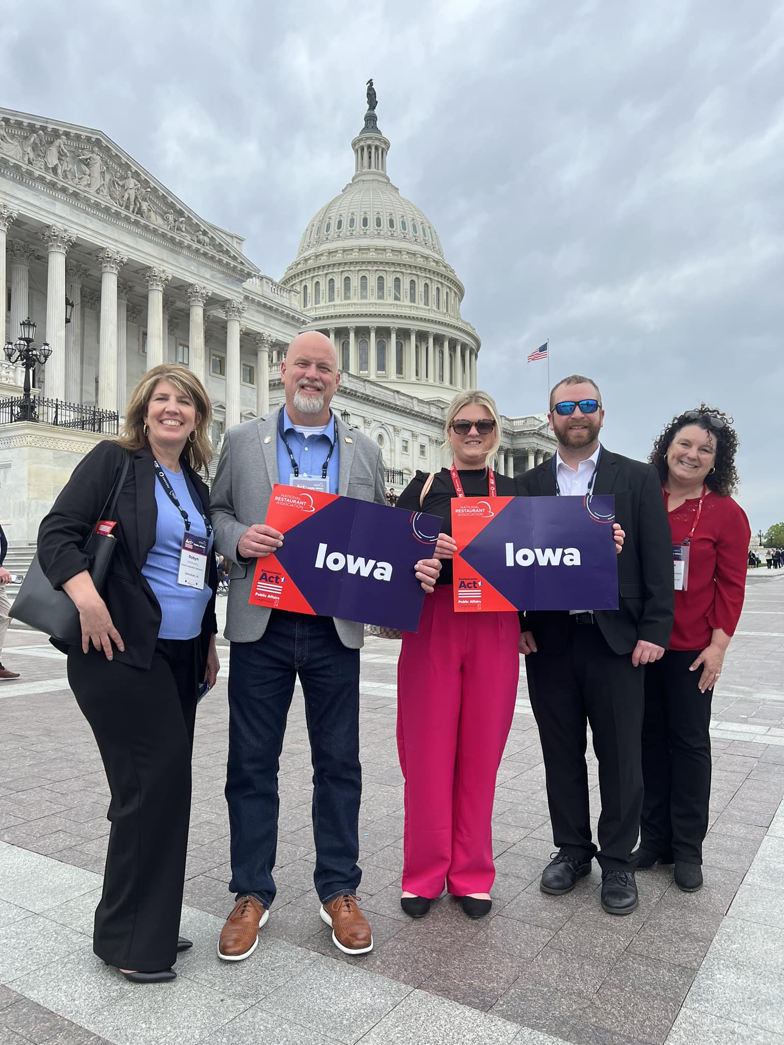 Group holding Iowa signs in front of the U.S. Capitol building during advocacy event.